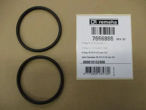 Zwei schwarze O-Ringe auf braunem Untergrund, neben einem Etikett mit Artikelnummer und Herstellerinformationen von Remeha.